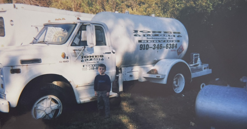 old picture of kid in front of Jones Propane truck